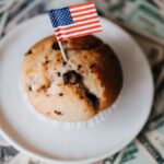International Foods - Tasty cake with flag on bunch of paper dollars