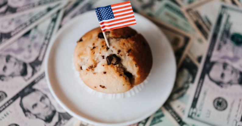 International Foods - Tasty cake with flag on bunch of paper dollars