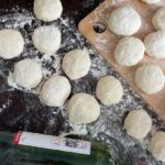 Slow Cooking - A table with dough, flour and a bottle of wine
