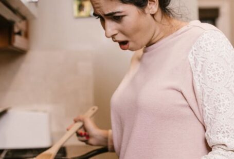 Online Cooking Classes - A Woman Looking at a Laptop while Cooking
