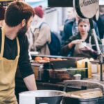 Food Festival - Man Standing in Front of Bowl and Looking Towards Left