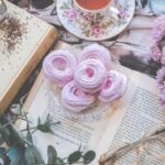 Coffee Ceremonies - Floral Ceramic Cup and Saucer Above Open Book